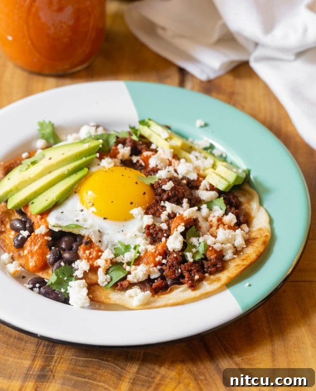 Hearty Ranch Eggs with Zesty Salsa 13 Finished Huevos Rancheros recipe with avocados, chorizo, queso fresco, beans and cilantro, ready to eat.