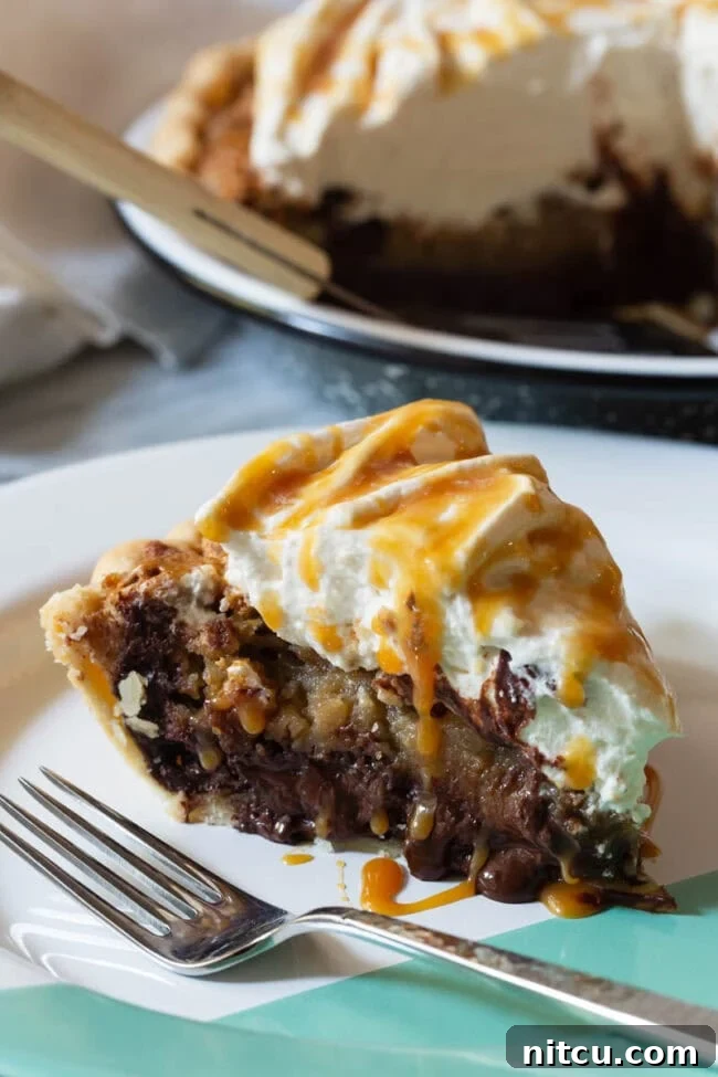 derby-pie A glorious slice of bourbon-infused chocolate pecan pie, served on a pristine white plate with a fork, ready to be enjoyed.