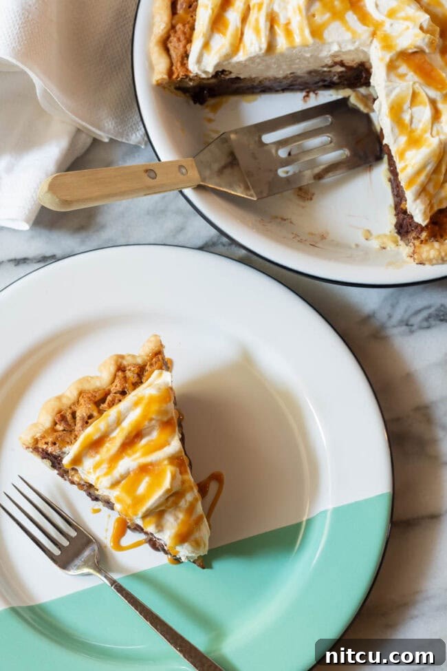 Kentucky-derby-pie A perfect slice of Kentucky Derby Pie, glistening with its rich filling and topped with a swirl of salted caramel whipped cream, rests on a beautiful white and green plate.