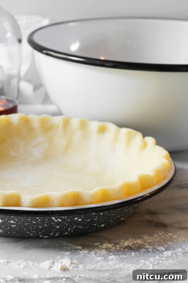 pie-crust An unbaked pie crust, perfectly crimped, waiting in a pie pan.