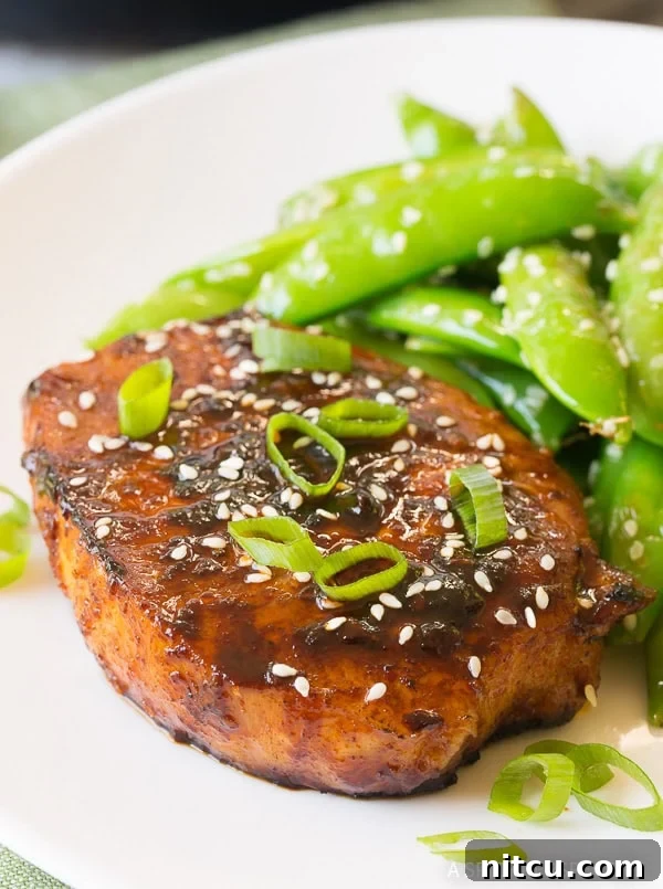 Close-up shot of Pan Fried Korean Pork Chops served on a plate, showcasing their rich glaze and tender texture.