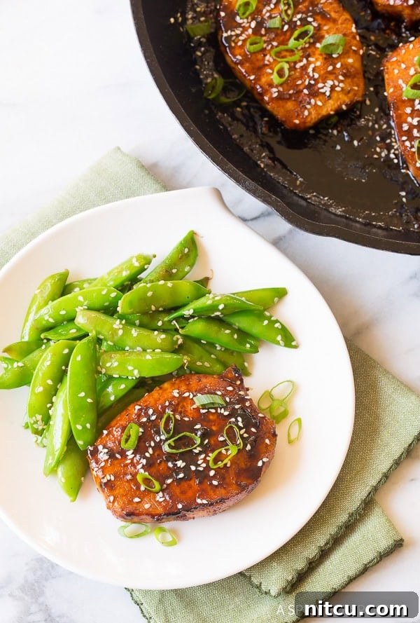 Spicy Korean Pork Chops presented in a skillet and alongside sugar snap peas on a plate, highlighting a complete meal.