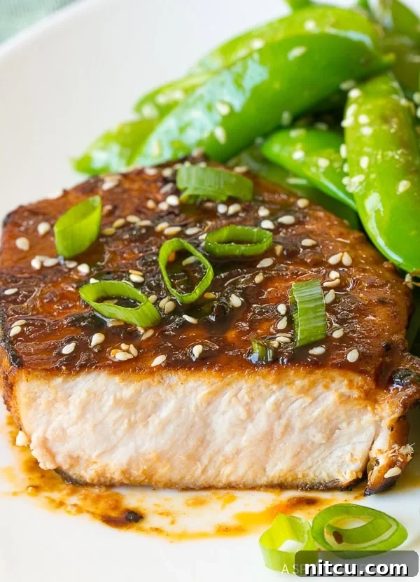 Close-up of zesty Pan Fried Korean Pork Chops, showing the vibrant glaze and appealing texture.