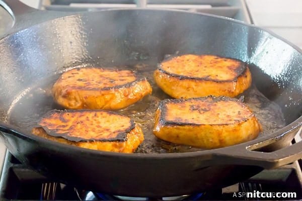 How to Fry Pork Chops - chops perfectly seared and glazed in a skillet.