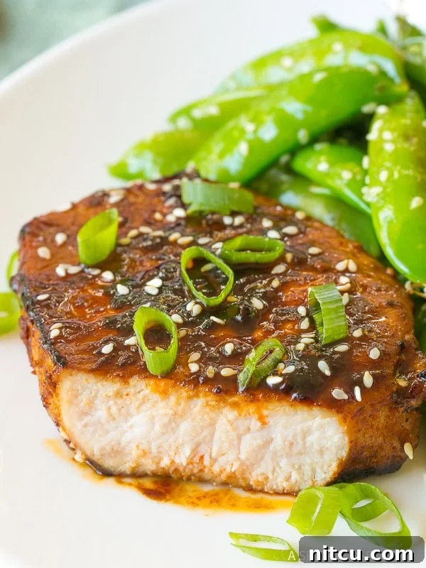 The Perfect Pan Fried Pork Chops with a beautiful, glossy glaze, ready to be served.