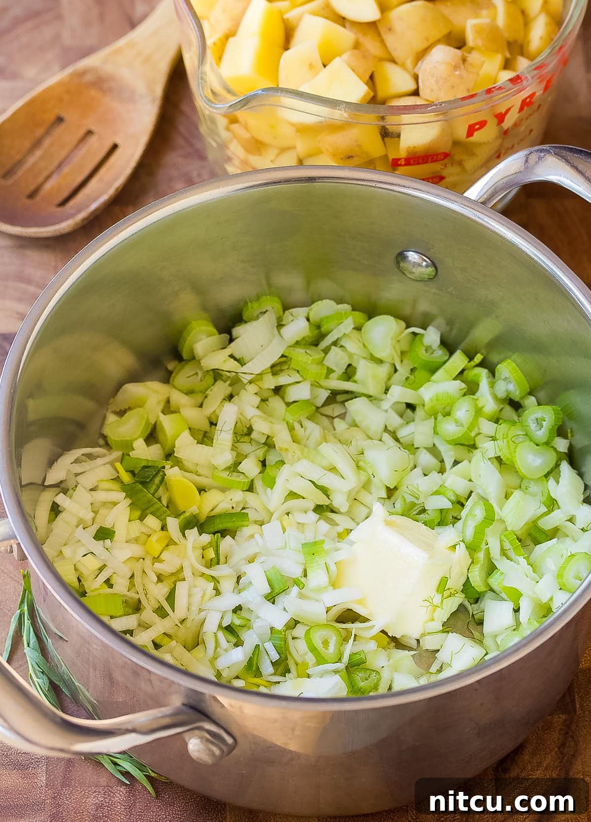 chowder recipe ingredients being added to a large soup pot, showing the cooking process