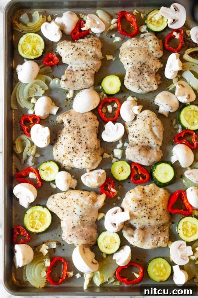 One-Pan Chicken Cacciatore 6 Sliced zucchini and mushrooms on a cutting board, prepared for the sheet pan cacciatore recipe