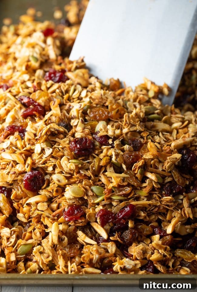 Wholesome Homemade Granola 6 Freshly mixed granola ingredients spread evenly on a baking sheet, ready for the oven.