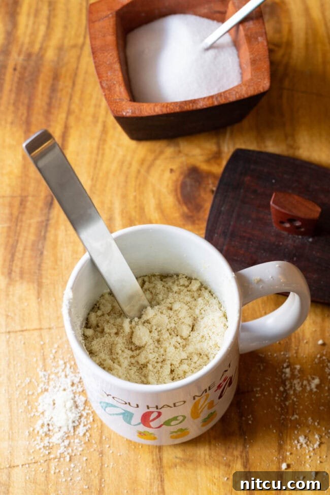 Effortless Keto Mug Bread 4 Mug with almond flour being mixed with a metal spoon.
