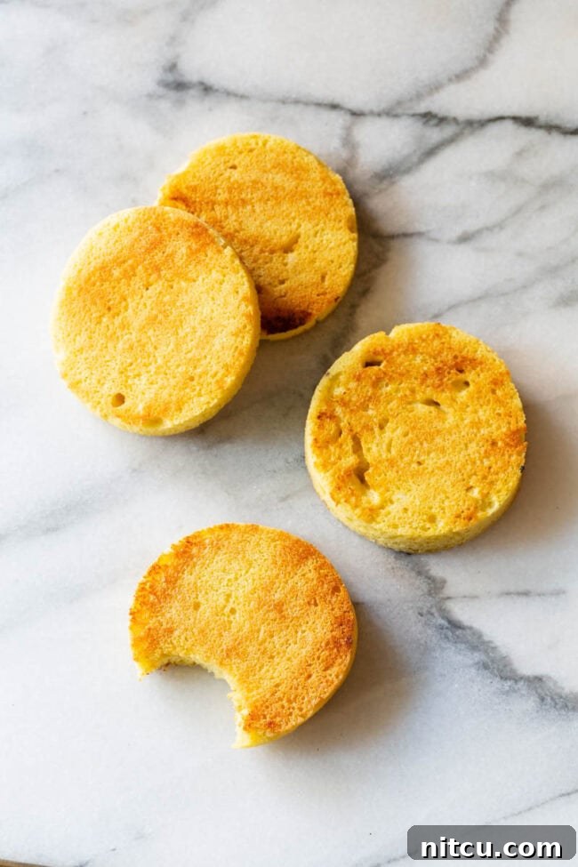 Magic Mug Low Carb Bread Recipe #ASpicyPerspective #Paleo #Ketogenic #SugarFree #DairyFree #GrainFree #GlutenFree 4 slices of low carb microwave mug bread on a marble background. One slice of bread has a bite taken out.