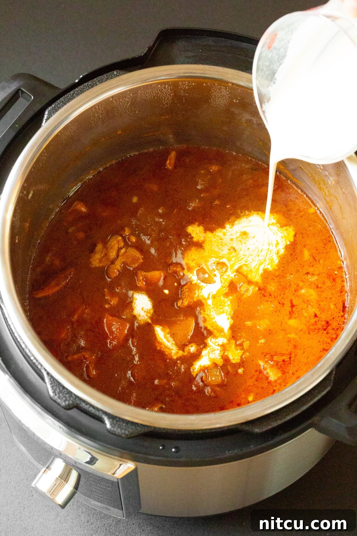 Cream being poured into Instant Pot. 