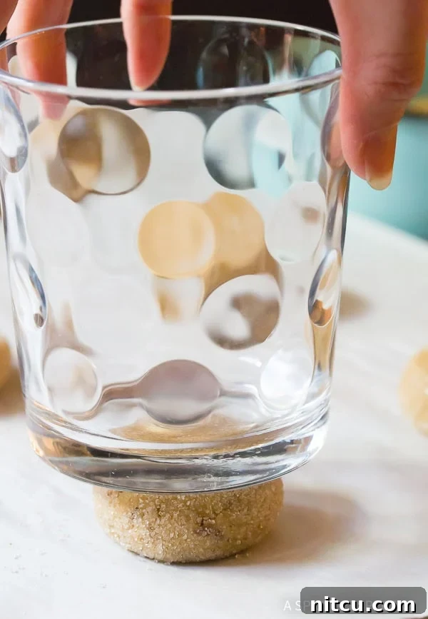 Nutty Brown Butter Delights 8 A drinking glass pressing down cookie dough to flatten it before baking.