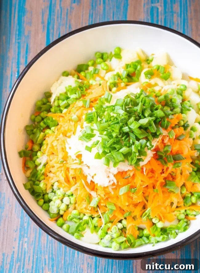Creamy Hawaiian Macaroni Potato Salad 4 Ingredients for Hawaiian style macaroni salad in a large mixing bowl before being mixed, showing fresh vegetables and pasta.