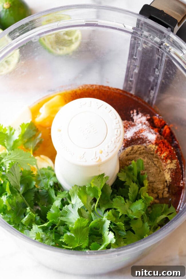 The Secret to Tender Carne Asada 5 Ancho chili powder and other spices being blended in a food processor for the Carne Asada marinade.