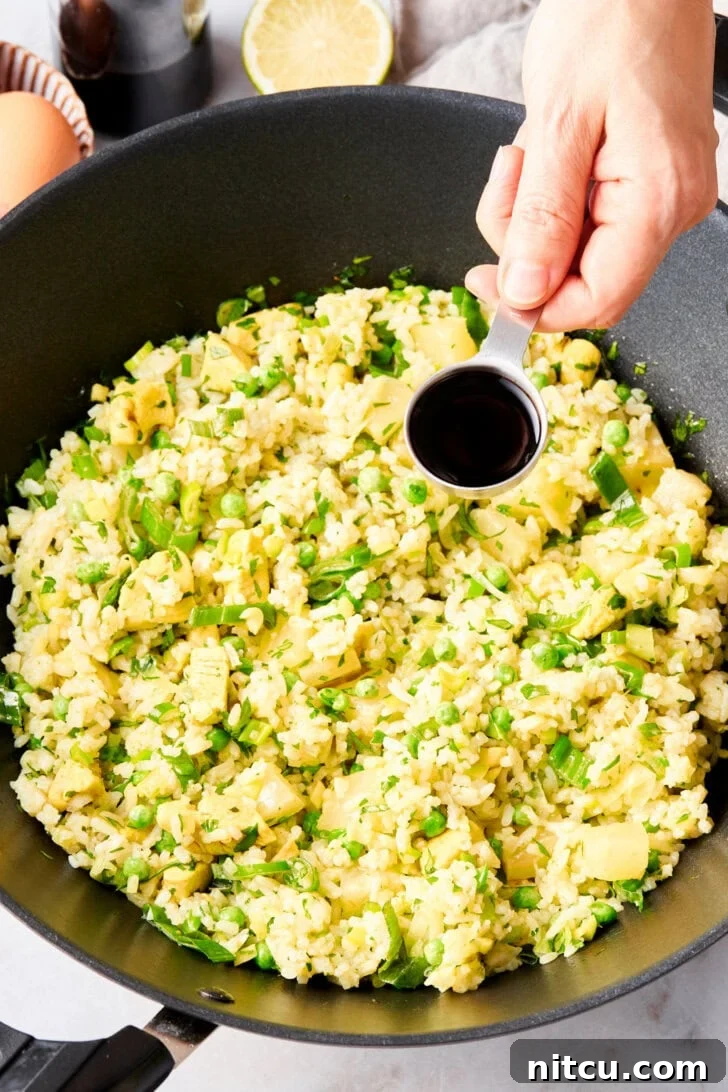 The Ultimate Thai Fried Rice 8 All the delicious ingredients for Thai fried rice tossed together in a large skillet, nearing completion.