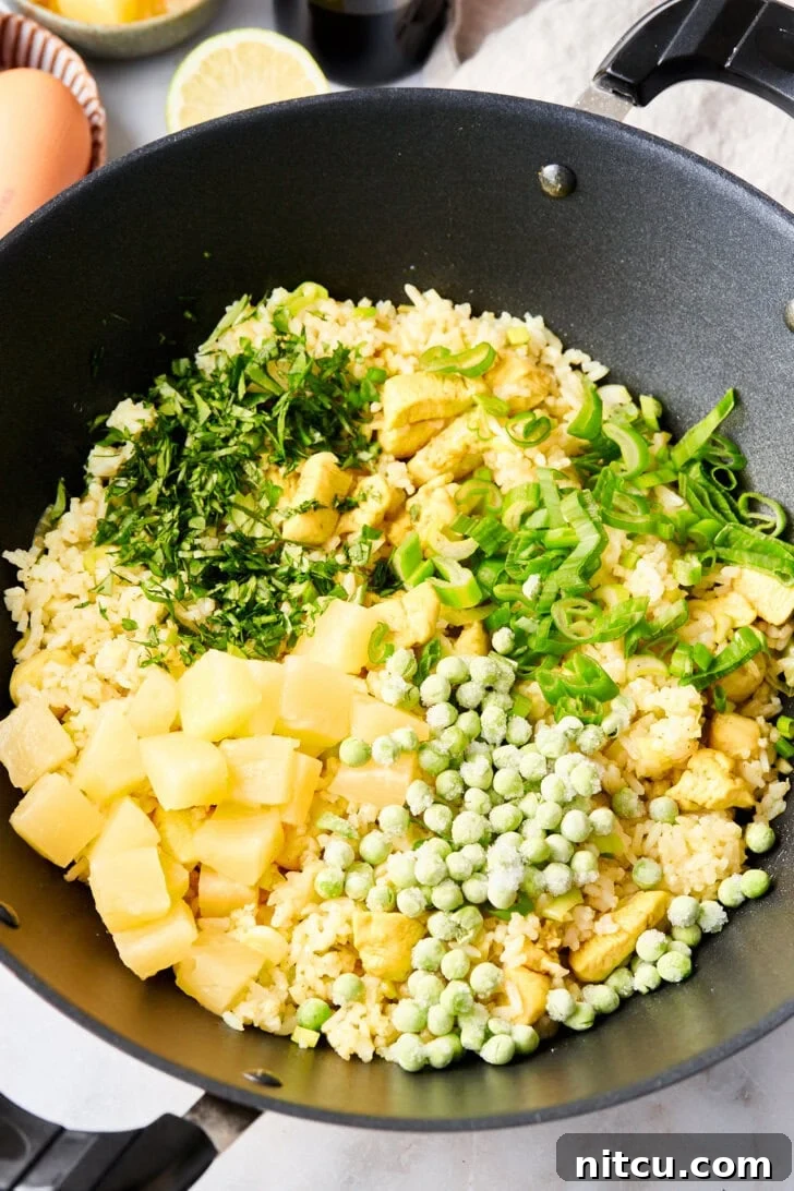 The Ultimate Thai Fried Rice 10 Colorful array of vegetables for Thai fried rice, expertly mixed in a large skillet, ensuring every component is perfectly cooked.