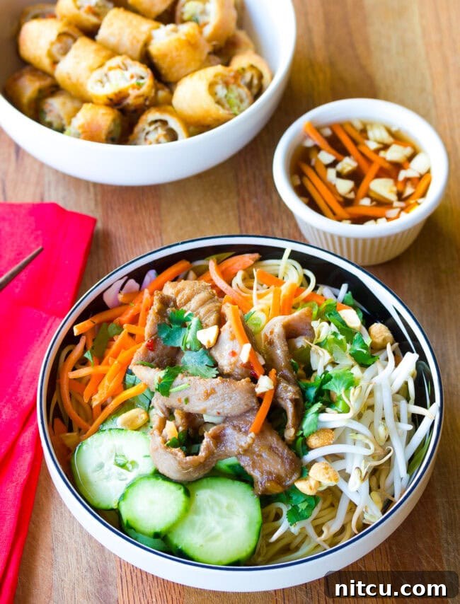 Vietnamese bun cha gio in a bowl with a small bowl of sauce on the side. 
