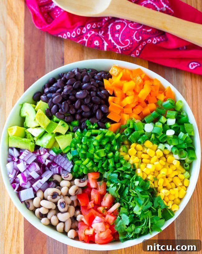 Bowl filled with fresh ingredients for cowboy caviar before mixing.