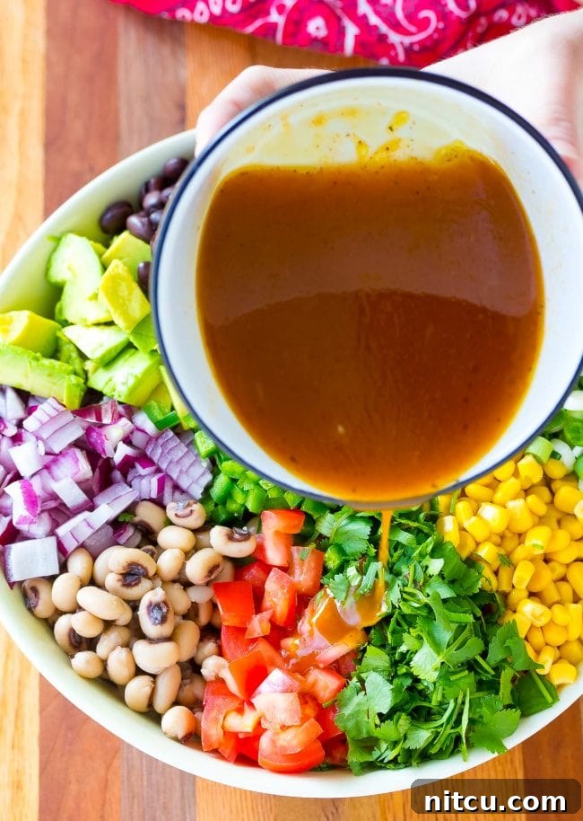 Zesty dressing being poured over the colorful caviar salad.