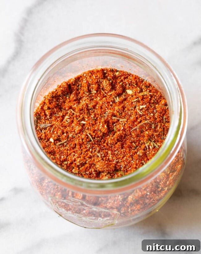 Assorted herbs and spices laid out, showcasing the ingredients that make up the perfect blackened seasoning blend.