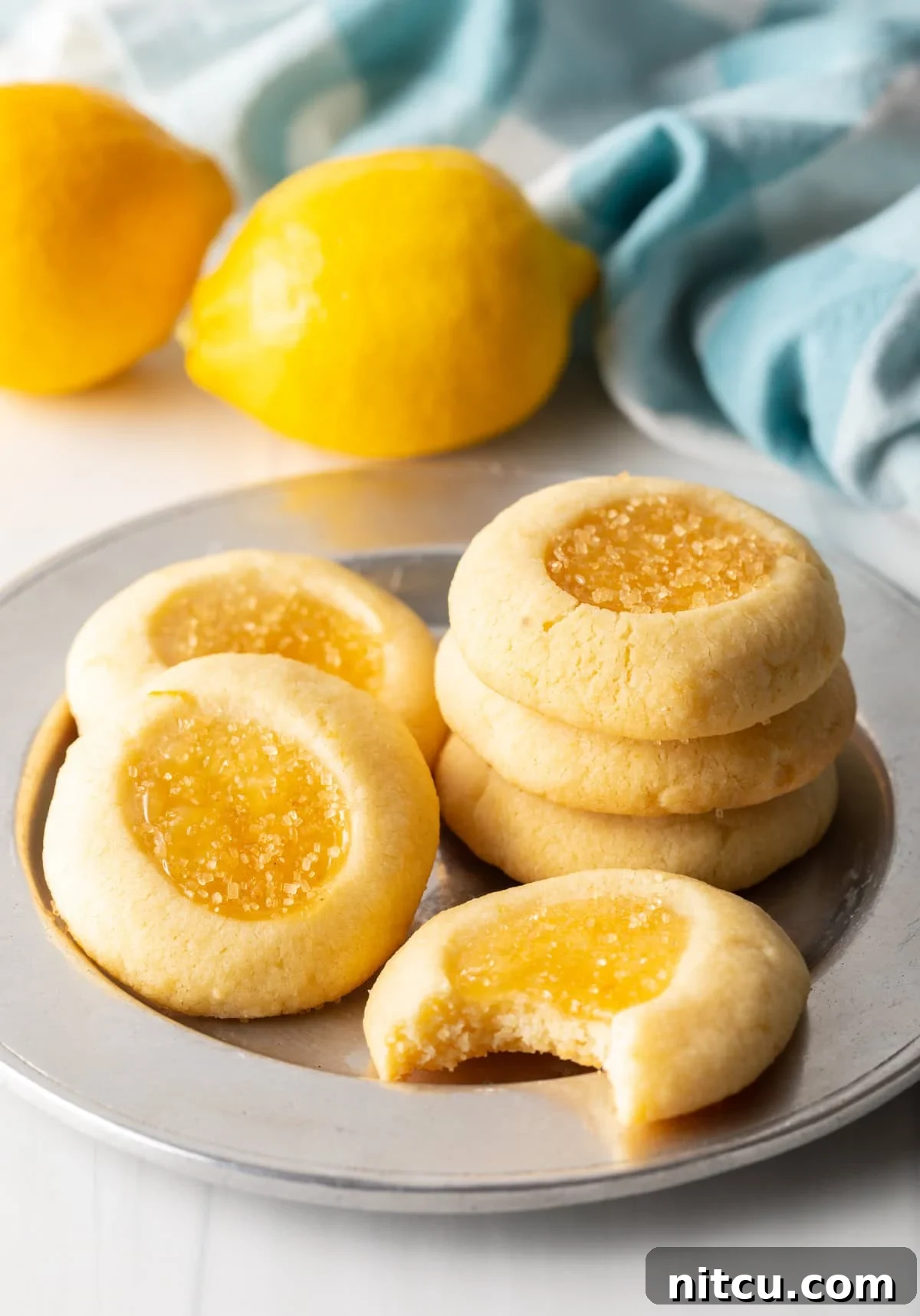 Sunshine Lemon Drop Cookies 7 Handful of lemon cookies laid out on a charger perfectly baked