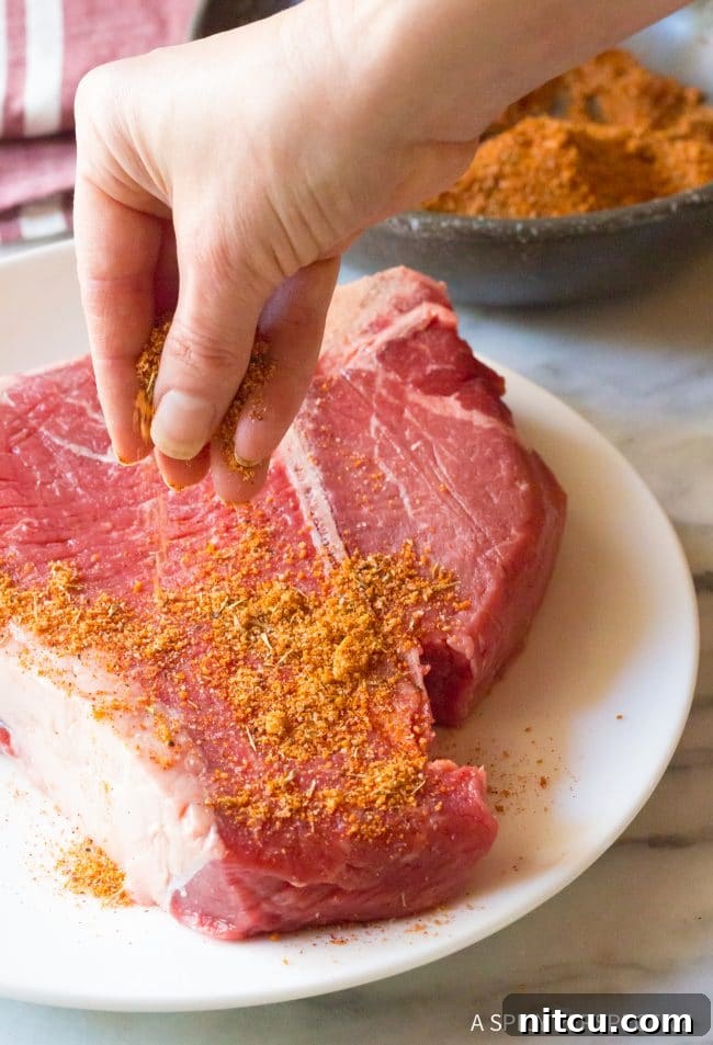 The Ultimate Steakhouse Seasoning at Home 4 A hand gently pouring spices into a bowl, starting the process of making homemade steak seasoning.