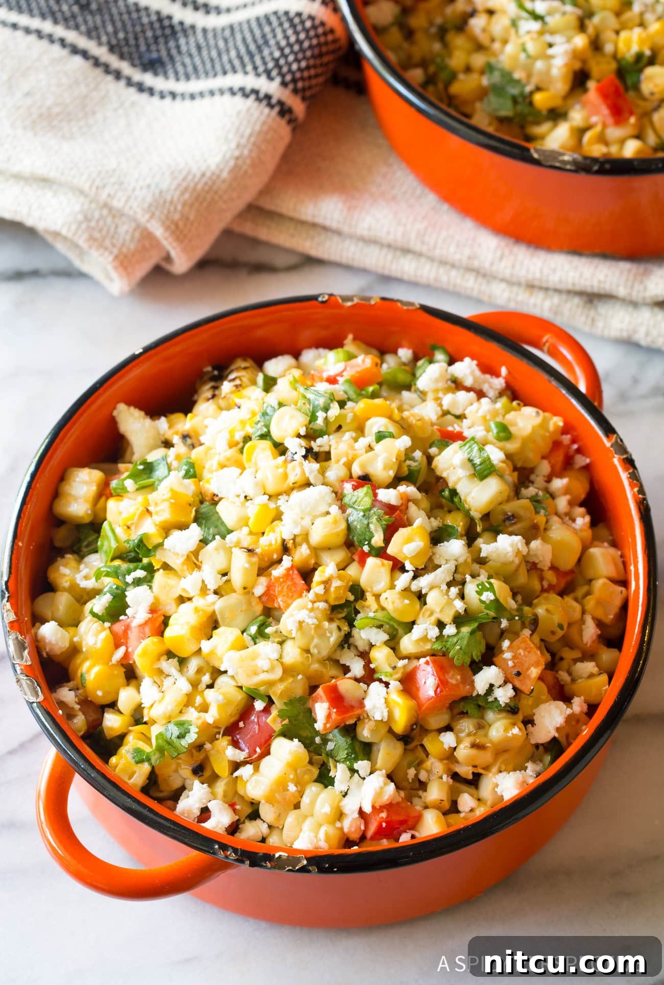 Charred Mexican Elote 10 Closeup of Mexican Street Corn Salad served in a vibrant orange bowl, ready to be enjoyed with a spoon.