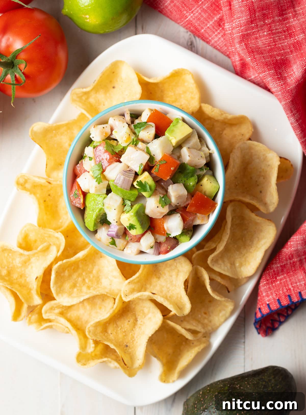 Fresh-Seafood Ceviche de pescado overhead shot in small bowl on platter with tortilla chip scoops