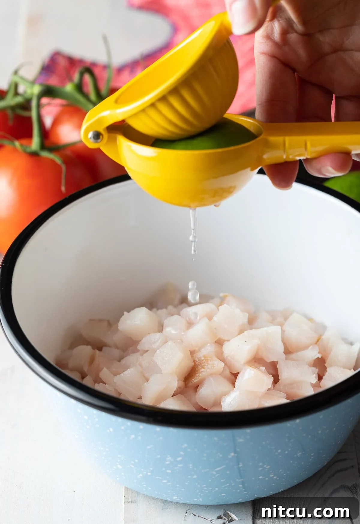 How to make ceviche - diced fresh fish in bowl with lime juice squeezed over the top