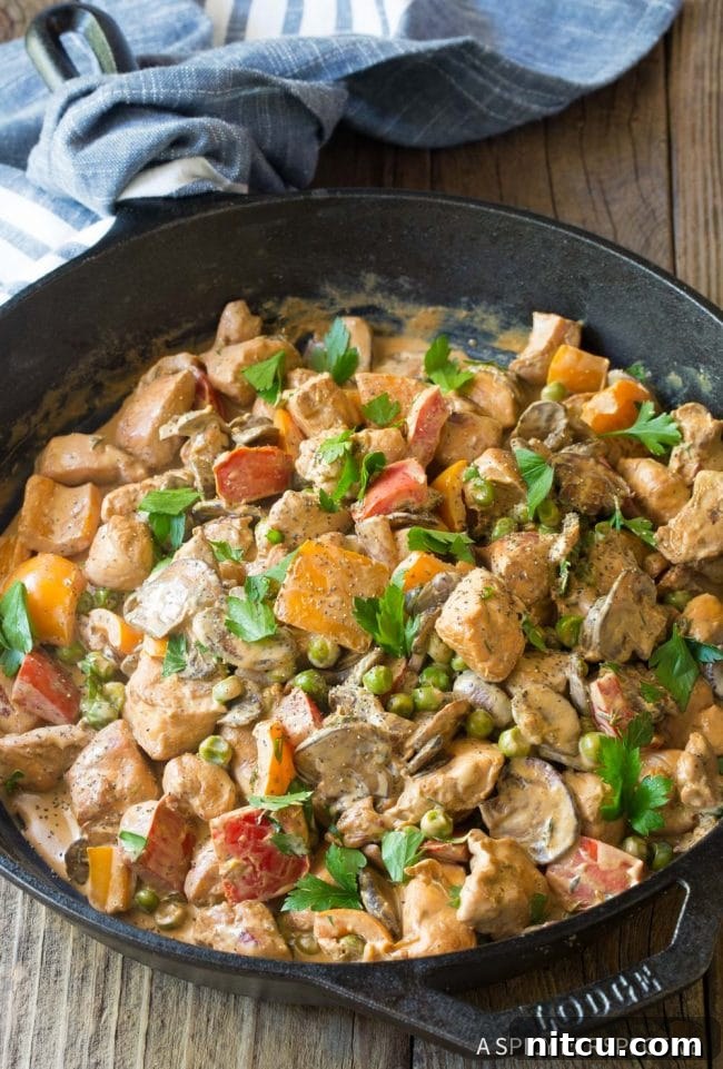 Lighter Chicken A La King 2 Creamy Healthy Chicken a la King in a cast iron skillet, garnished with fresh parsley.