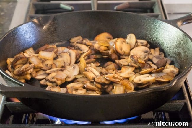 Lighter Chicken A La King 6 Mushrooms being sauteed until golden brown in a skillet.