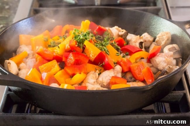 Lighter Chicken A La King 9 Chopped bell peppers added to the chicken and mushroom mixture in a skillet.