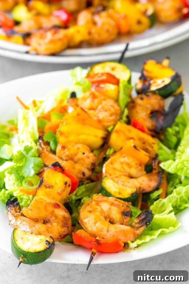 Sweet and Savory Glazed Teriyaki Shrimp 11 Closeup shot of perfectly cooked shrimp skewers on a white plate, showcasing their vibrant colors and juicy appearance.