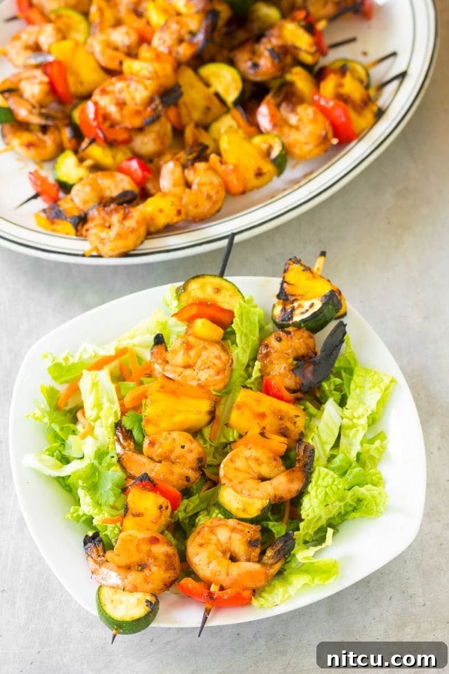 Sweet and Savory Glazed Teriyaki Shrimp 4 Top view of two perfectly grilled teriyaki shrimp skewers on a plate, showcasing their vibrant colors and juicy texture.