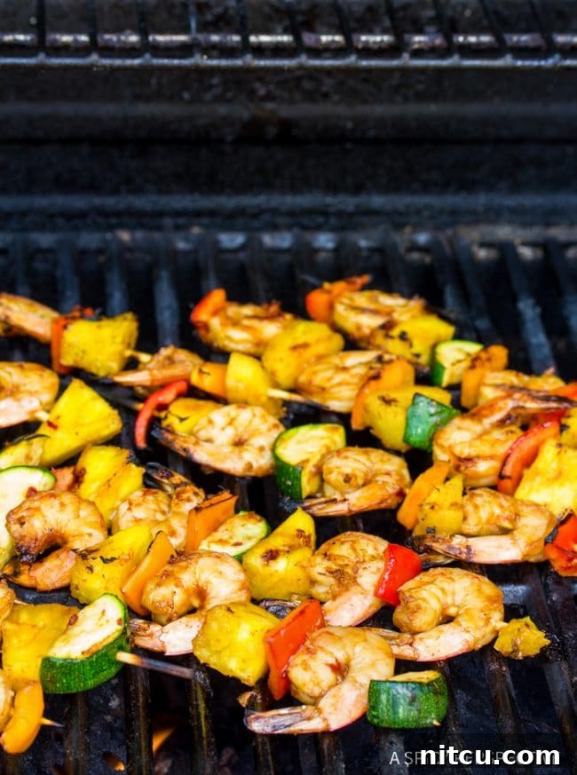 Sweet and Savory Glazed Teriyaki Shrimp 10 Vibrant shrimp skewers grilling on an outdoor barbecue, with visible smoke and char.