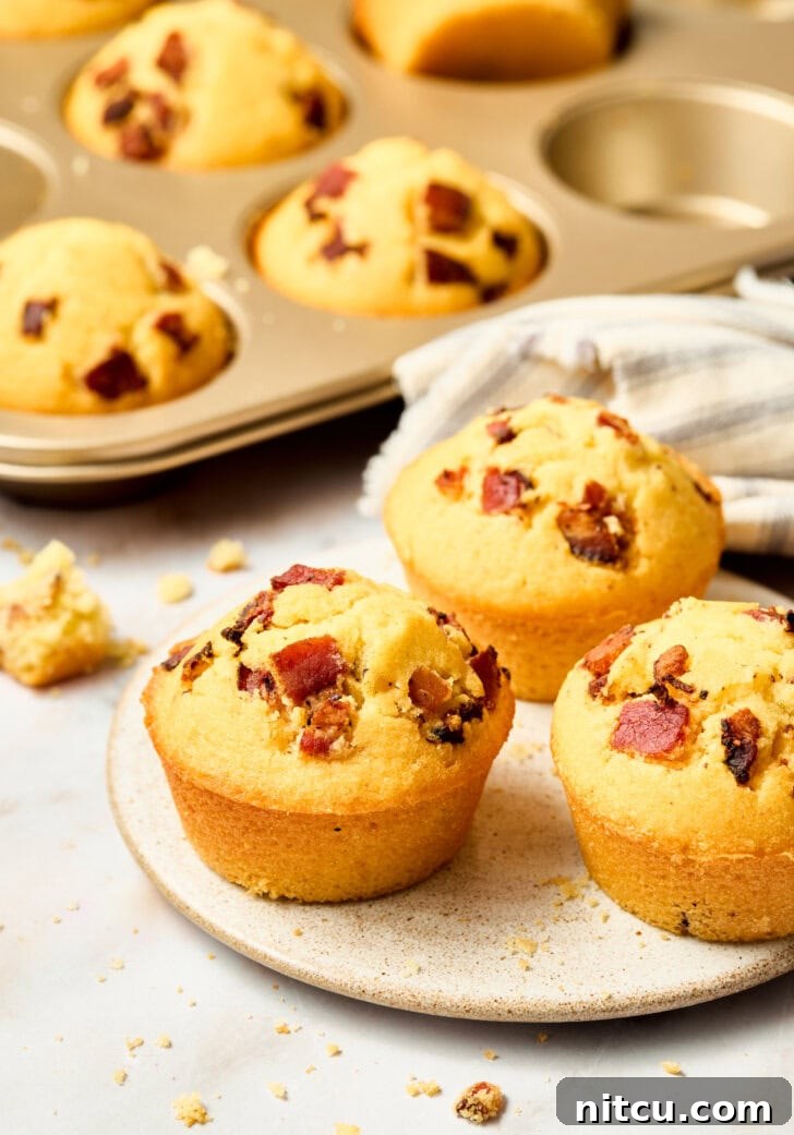 Golden Corn Muffins with Crispy Bacon 12 Easy cornbread muffins in a pan, topped with bacon and maple syrup