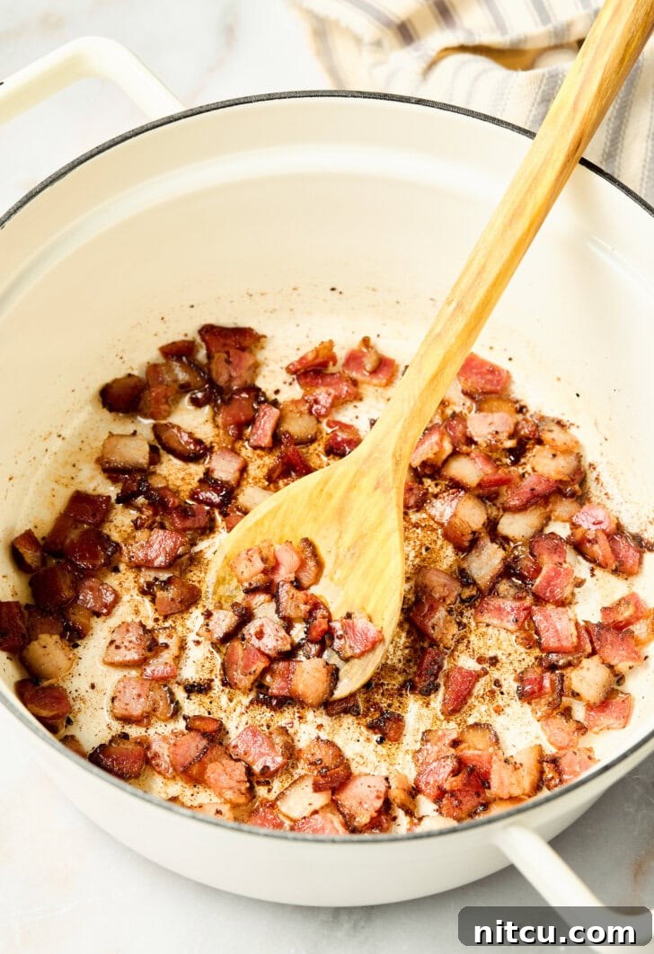 Golden Corn Muffins with Crispy Bacon 6 Bacon cooking in a skillet on the stovetop
