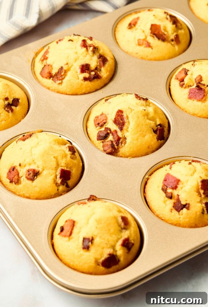 Golden Corn Muffins with Crispy Bacon 9 Freshly baked golden corn muffins in a muffin pan