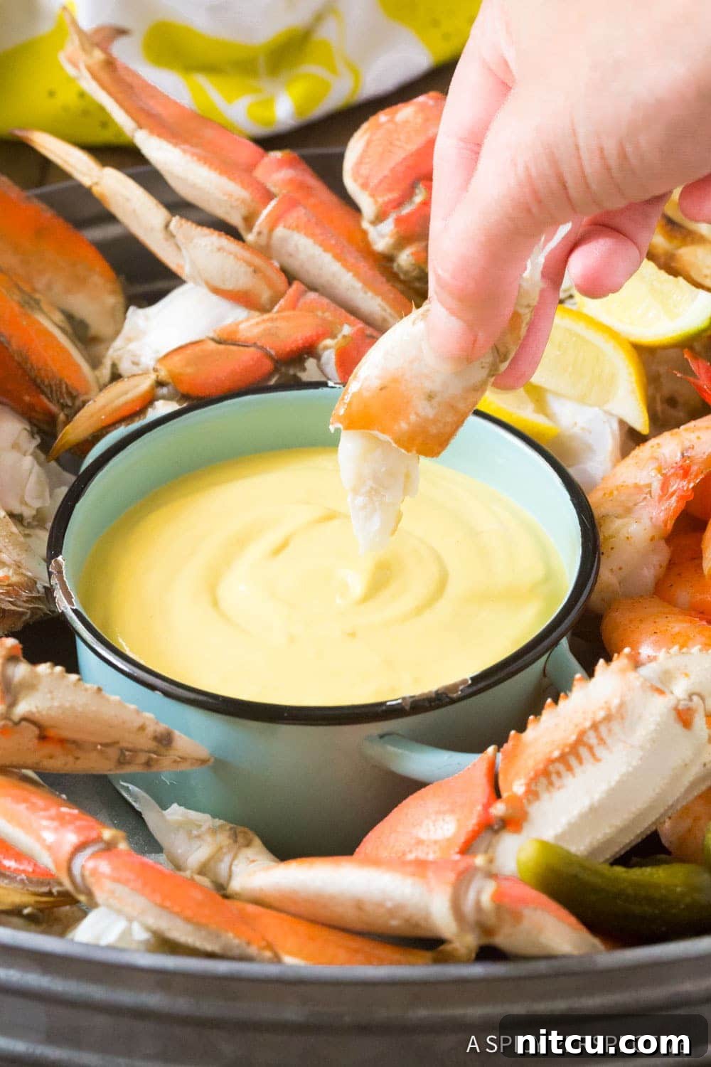 Mustard-Dipping-Sauce A small bowl of creamy mustard seafood dipping sauce placed elegantly on a serving platter alongside fresh crab, inviting diners.