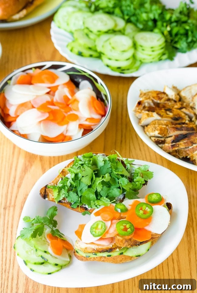 Vietnamese Baguette Masterpiece 6 Vietnamese Banh Mi recipe - sandwiches on plates piled high with vegetables and herbs