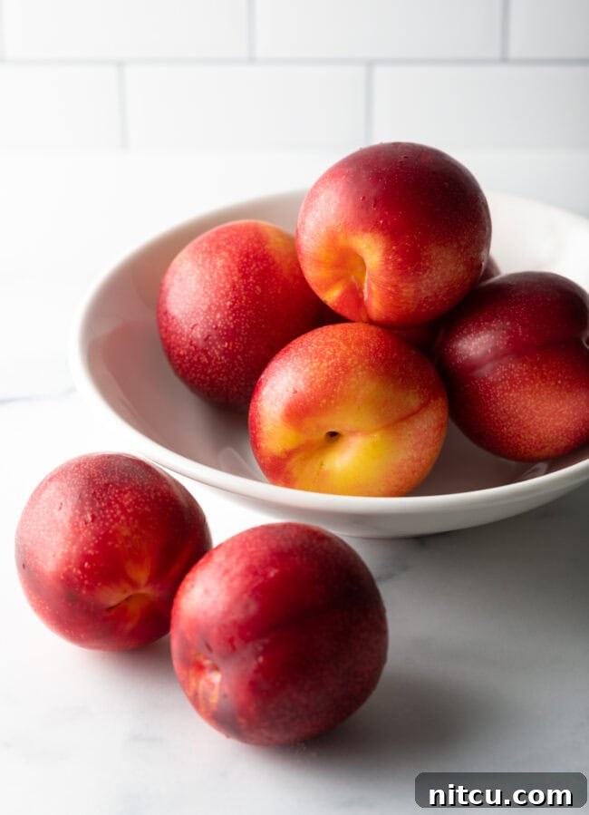 A close-up shot of several vibrant red and purple fresh plums, ready for baking.