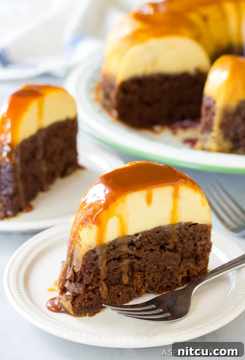 Impossible Chocoflan Cake 12 Individual slices of Chocoflan Impossible Cake on dessert plates, with the rest of the cake blurred in the background.
