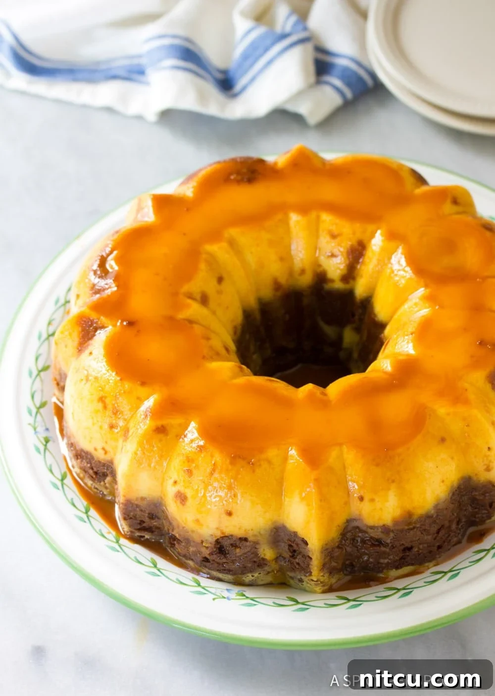 Impossible Chocoflan Cake 4 A freshly baked Mexican Chocoflan Impossible Cake, inverted onto a serving platter and glistening with cajeta caramel sauce.