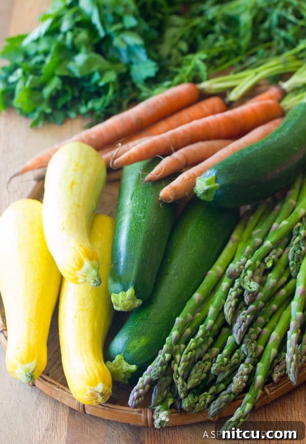 Flame-Kissed Pork Tenderloin with Bright Chimichurri and Rustic Roast Vegetables 3 Assortment of fresh, colorful vegetables ready for roasting, including vibrant green zucchini, yellow summer squash, crisp asparagus spears, and sweet orange carrots.