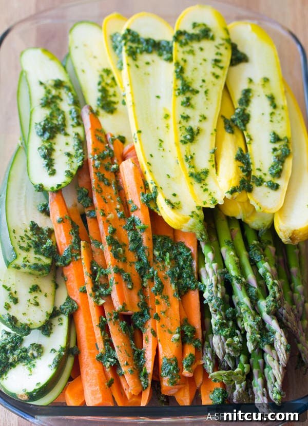 Flame-Kissed Pork Tenderloin with Bright Chimichurri and Rustic Roast Vegetables 5 Sliced vegetables like zucchini and summer squash tossed with vibrant green chimichurri sauce in a bowl, ready for grilling or roasting.