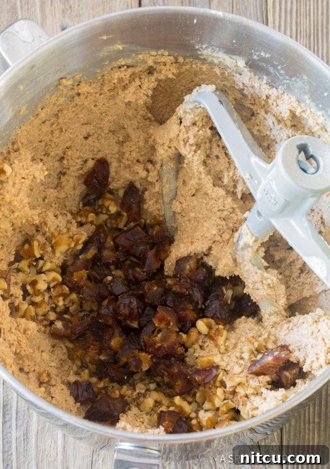 Wholesome Eggless Oat Bars 8 Breakfast oatmeal bar mixture being blended in a food processor with dates and nuts on top, indicating the mixing stage.