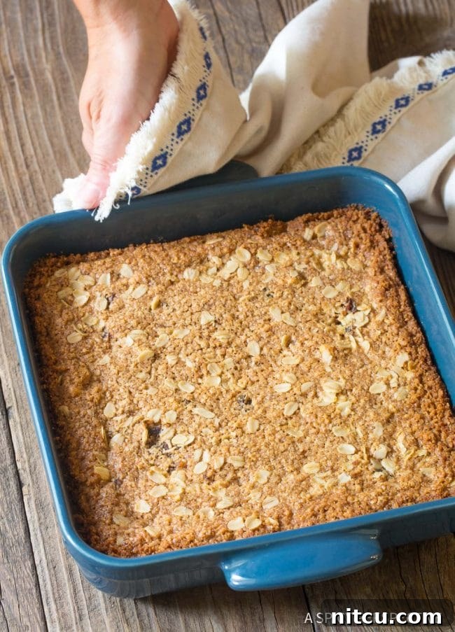 Wholesome Eggless Oat Bars 9 A full pan of freshly baked oat bars in a blue baking dish, golden brown and ready to cool.