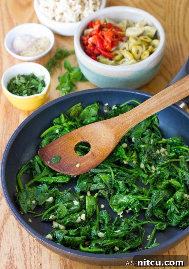 Savory Greek Omelette Bake 4 Sauteed spinach and garlic sizzling in a frying pan, releasing their aromatic flavors.