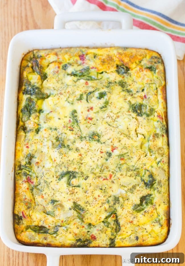 Savory Greek Omelette Bake 7 A golden-brown baked Greek omelette casserole, hot and ready to be served from its dish.