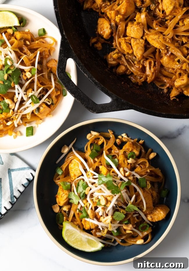 Classic Chicken Pad Thai Stir-fry 3 Overhead shot of Pad Thai noodles in a bowl garnished with mung bean sprouts, lime wedges, and fresh cilantro, showcasing its vibrant freshness.